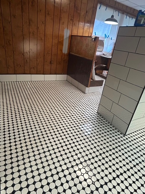 Restaurant restroom with black and white octagon mosaic tile floor and subway tile wall