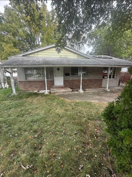 House exterior before renovation with tan siding and dated brick