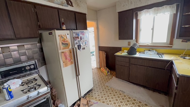 Outdated kitchen with dark cabinets and yellow laminate counters